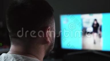 一个长胡子的白人男子在家里看<strong>电视屏幕</strong>上的狱卒录像