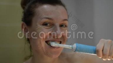 年轻女子用<strong>电动牙刷</strong>刷牙