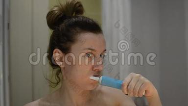 年轻女子用<strong>电动牙刷</strong>刷牙