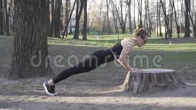 适合女人在树林里<strong>锻炼</strong>，在<strong>公园</strong>的原木上做俯卧撑。 在露天自然健身房<strong>锻炼</strong>。 俯卧撑。 吸引力