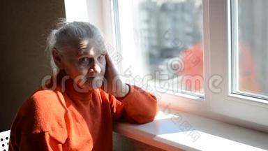阳光明媚的一天，一位老妇人望着窗外