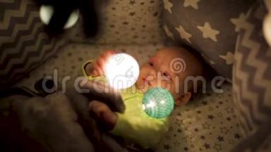 幼儿在床上活动.. 手持相机抖动.. 一个刚出生的婴儿玩灯光