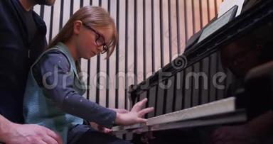 爸爸给女儿教<strong>钢琴</strong>。 小女孩在家学<strong>钢琴</strong>。 侧视。 家里的<strong>钢琴</strong>课。 儿童学习