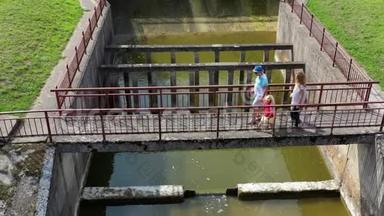 一家四口人走过大坝桥。 空中无人机射击