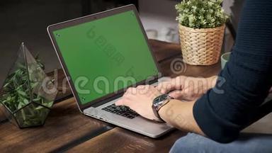 桌上的人正在绿色笔记本电脑屏幕上浏览<strong>互联网</strong>。 在一个<strong>光线</strong>充足，舒适的公寓里。 一个人在工作