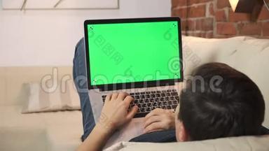 桌上的人正在<strong>绿色</strong>笔记本电脑屏幕上浏览互联网。 在一个<strong>光线</strong>充足，舒适的公寓里。 一个人在工作