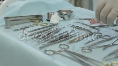 戴白橡胶手套的医生在牙科诊所的桌子上放置牙科工具