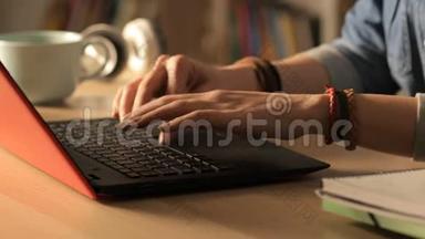 晚上在家学习的学生在笔记本电脑上<strong>打字</strong>
