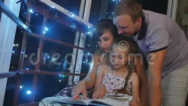 妈妈、<strong>爸爸和女儿</strong>在睡觉前坐在夜窗附近。 <strong>女儿</strong>读了一本大童话书