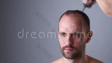 理发师用<strong>剪发</strong>器剪人的头发。