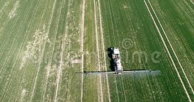 拖拉机在田间农业工作。 农民在田间喷洒化学物质GMO。 食品生产。