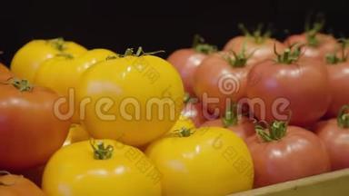 红色和黄色的西红柿躺在杂货店的货架上。 摄像机沿着各种健康的新鲜蔬菜移动
