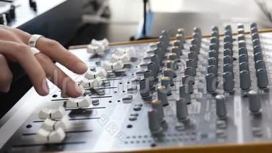 录音室的年轻人。 使用混合控制台关闭双手。 专业录音。
