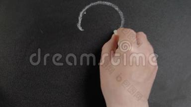 问号。 人用粉笔在黑板上写下问号