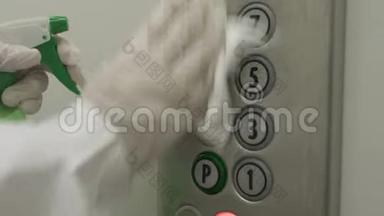 女士使用湿擦和酒精消毒喷雾清洁电梯按钮控制面板。 消毒