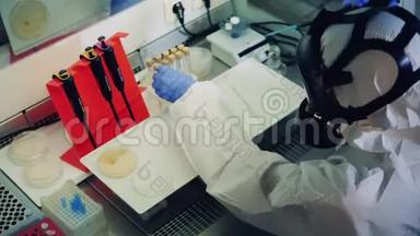 一名工人在实验室工作时使用吸管，为Covid19疫苗接种<strong>取样</strong>。