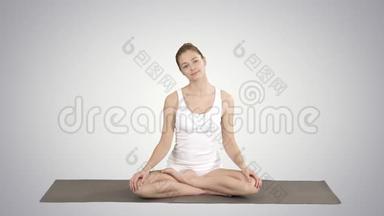 平静的女人练习瑜伽，坐在莲花的姿势，伸展<strong>颈部</strong>的梯度背景。