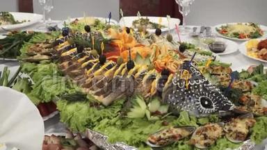 节日桌上有水果、蔬菜、<strong>菜肴</strong>、鱼和肉。 为客人的到来而精心装饰。
