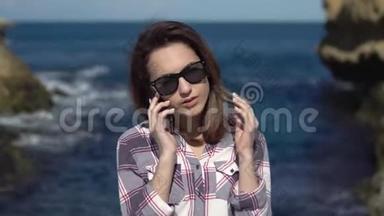 一个年轻的女人在<strong>大海</strong>的背景下打电话给智能手机。 有电话的女人在度假。 蓝色的<strong>大海</strong>