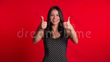 年轻的拉丁女人，穿着完美的妆容，竖起大拇指，在红色上<strong>签</strong>名