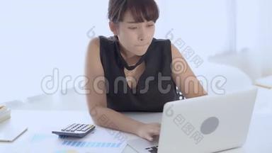 女商人计算开支，在办公桌上打手提电脑，<strong>节省</strong>开支