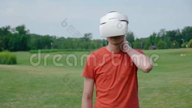 一个男人在公园里用VR耳机抓脖子