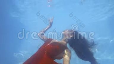 美丽的红衣女子漂浮在水下，触摸水面，4K