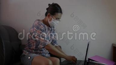 在隔离期间戴防护面罩在家工作的亚洲妇女。