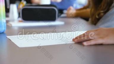 以色列白人少女天才少女在一个小学班级的笔记本上写字