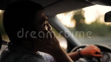 英俊的年轻人在开车时用手机说话。 冒险，鲁莽司机的坏习惯.. 交通安全