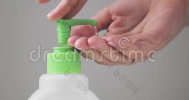 人按在配药瓶上，用<strong>消毒液</strong>清洁双手，特写视图。