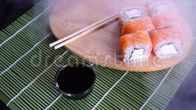 装饰竹餐巾纸上有<strong>酱油</strong>的木板上的美味卷。 提供美味的<strong>寿司</strong>卷