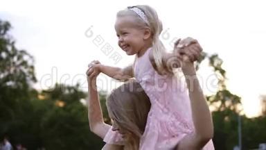快乐的白种人母亲把美丽的小女儿扛在肩上，在公共<strong>场合</strong>一起跳舞和玩
