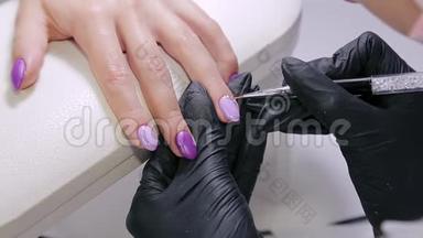 美容院的美甲师给顾客的指甲涂上带<strong>水钻</strong>的凝胶清漆