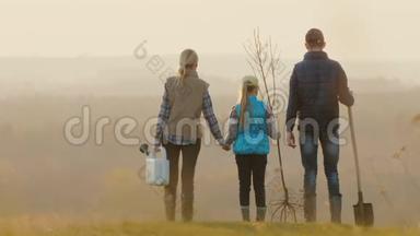 一家人有一棵树苗，一辆洒水车和一把铲子，站在风景如画的地方