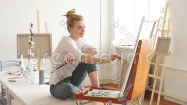 <strong>才华</strong>横溢的艺术家坐在桌子上，在家画她的画