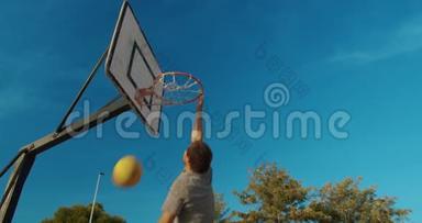 男篮球员在室外篮球场上灌篮。