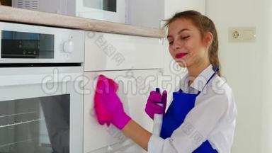 打扫房间，用粉红色手套和粉红色抹布擦拭白色表面。 一个涂口红的女孩做清洁