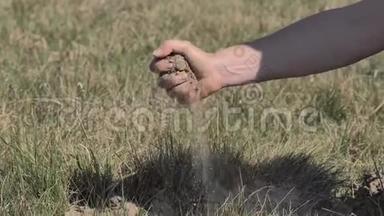 农夫双手捧着一把干土，用手指慢慢倒下去.. 农民保持干燥的土壤。