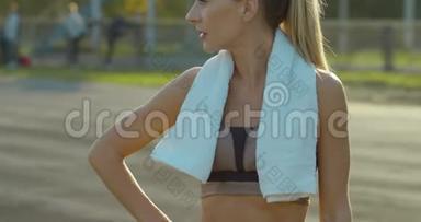 年轻女子运动员在经过激烈训练后在体育场跑步休息。