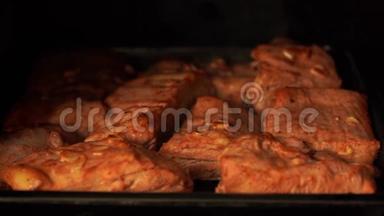 把烤好的排骨放在烤箱里的托盘上。 加蒜的调味肉在烤箱里炒。