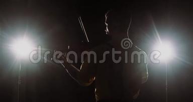 男职业小提琴手小提琴演奏聚光灯小提琴的剪影，后景。