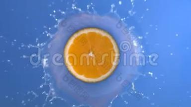 橙色鲜果落入蓝水液与旋转溅与滴在慢运动顶部拍摄