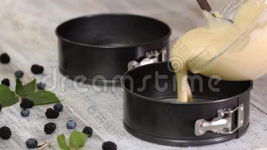 女人`手把蛋糕面糊倒入蛋糕模具，准备烘焙。