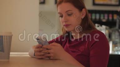 年轻的女人坐在咖啡馆里，用手机打字。 网店的概念..