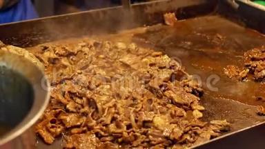 街头小贩在夜市烹制韩国烧烤羊肉