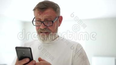 一位手里拿着手机的英俊男子的特写肖像。 祖父收到了他孙子的留言