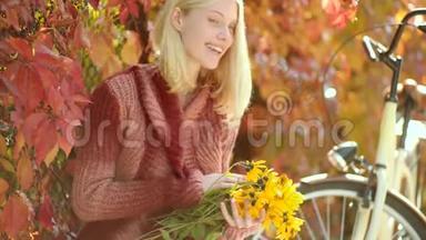 秋天和树叶飘落的梦想。 秋天的女人在公园里玩得很开心，笑着。 穿着针织毛衣留长发的梦幻女孩