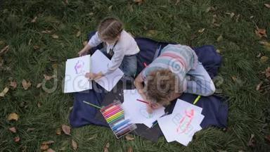 两个快乐的孩子，男孩和女孩躺在<strong>夏日</strong>公园的<strong>绿草</strong>地上。孩子们的兄弟姐妹是读书、画画、玩耍、大笑。