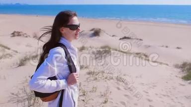带着背包的女旅行者正在度假的沙滩上<strong>四处</strong>寻找。